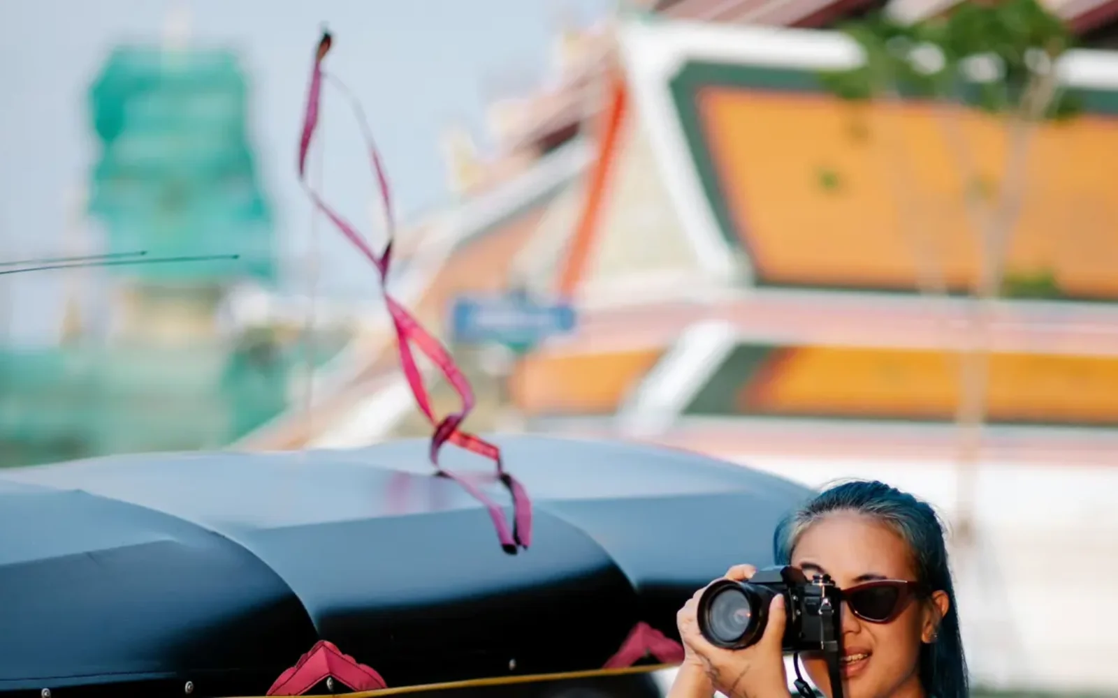 A traveler photographing a bright city street in summer