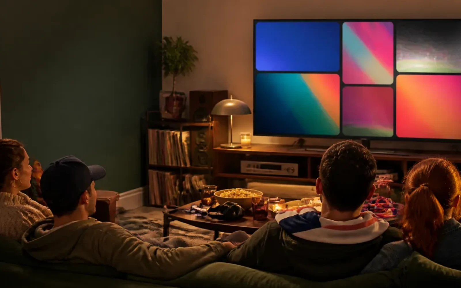 Friends watching a modern streaming screen in a warm living room with vintage media details