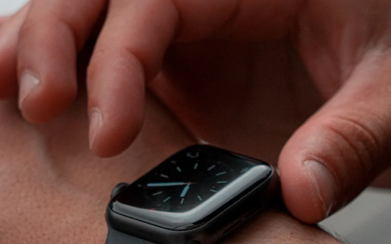 A person adjusting a smartwatch on their wrist